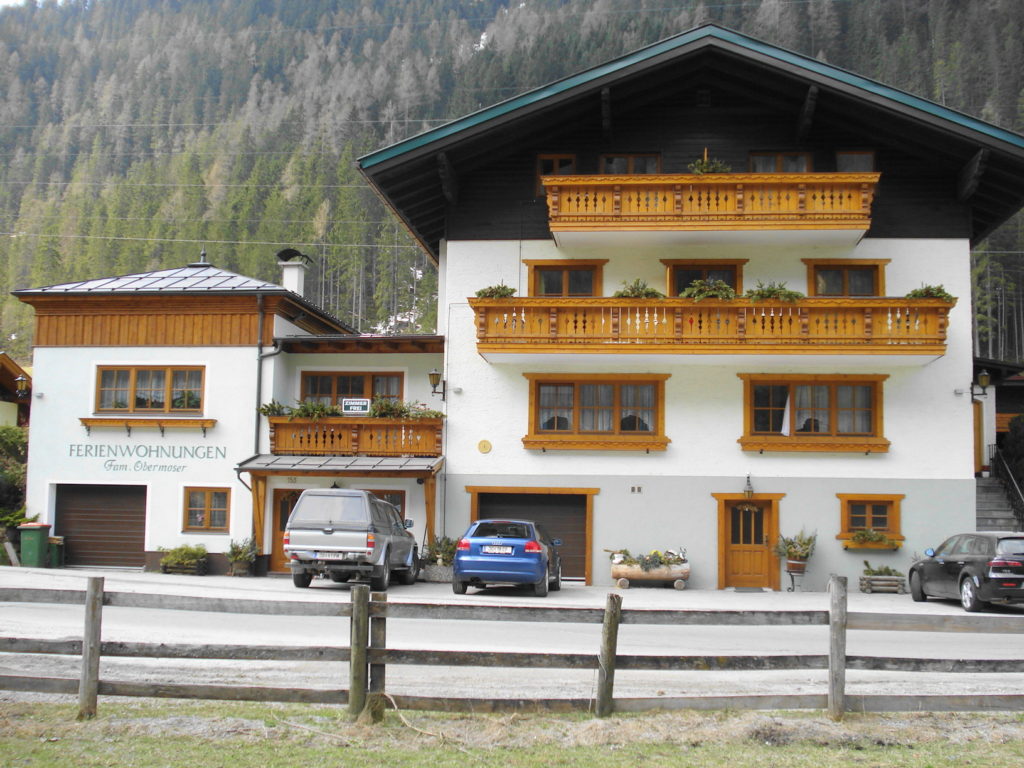 Fassade mit dunklem Holz und verblichener Farbe vor den Renovierungsarbeiten.